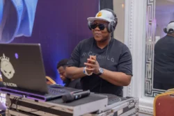 DJ performs live at a professional event setup with laptop, turntables, and headphones. DJ performing live at a professional event setup with laptop, turntables, and headphones.