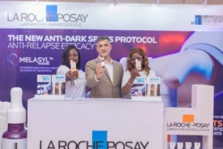La Roche-Posay anti-dark spots protocol booth with smiling presenters and skincare products. La Roche-Posay anti-dark spots protocol event with product display and smiling presenters.