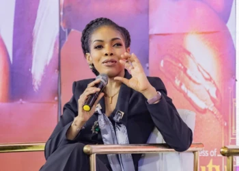Stylish woman speaks into a microphone during a panel discussion event. Stylish woman speaks into microphone at panel discussion event.