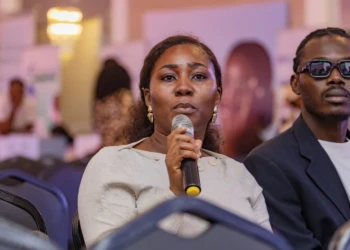 Woman speaking into a microphone at a conference event. Woman speaking into microphone at conference event with seated audience.